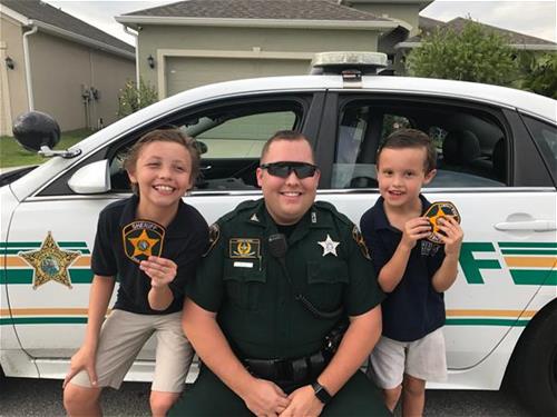Deputy with kids in front of patrol car